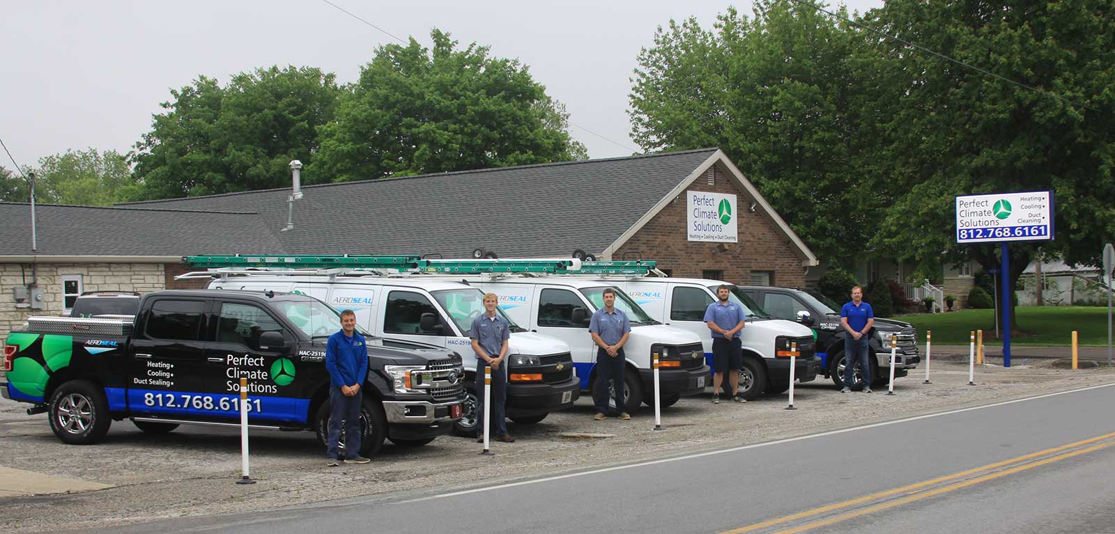 Perfect Climate Heating and Air team standing outside next to service vehicles